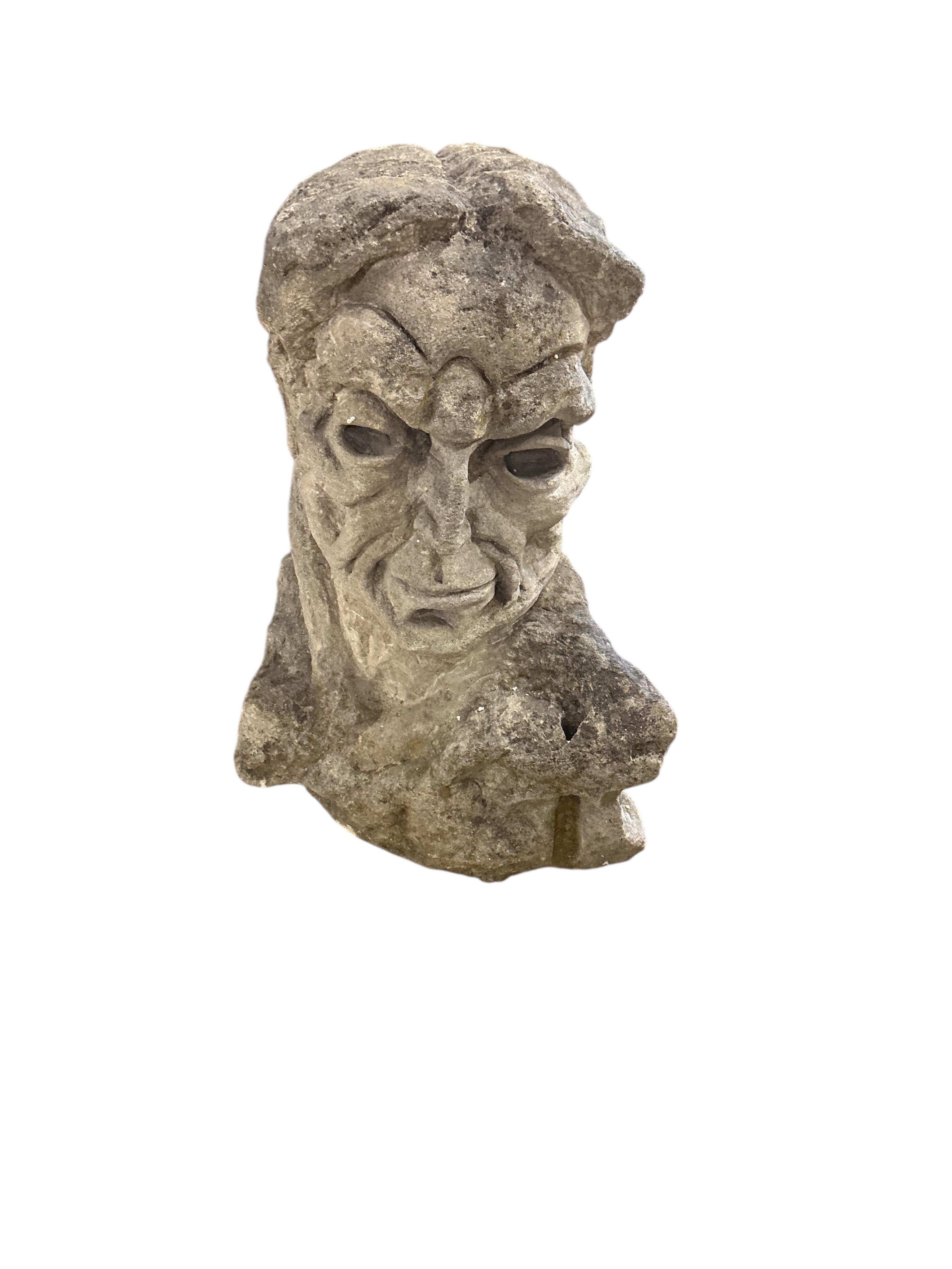 A carved stone head, height 69cm